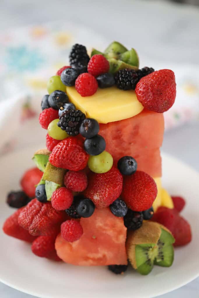 A fresh fruit cake design using watermelon and pineapple along with berries, kiwi, and mangos.