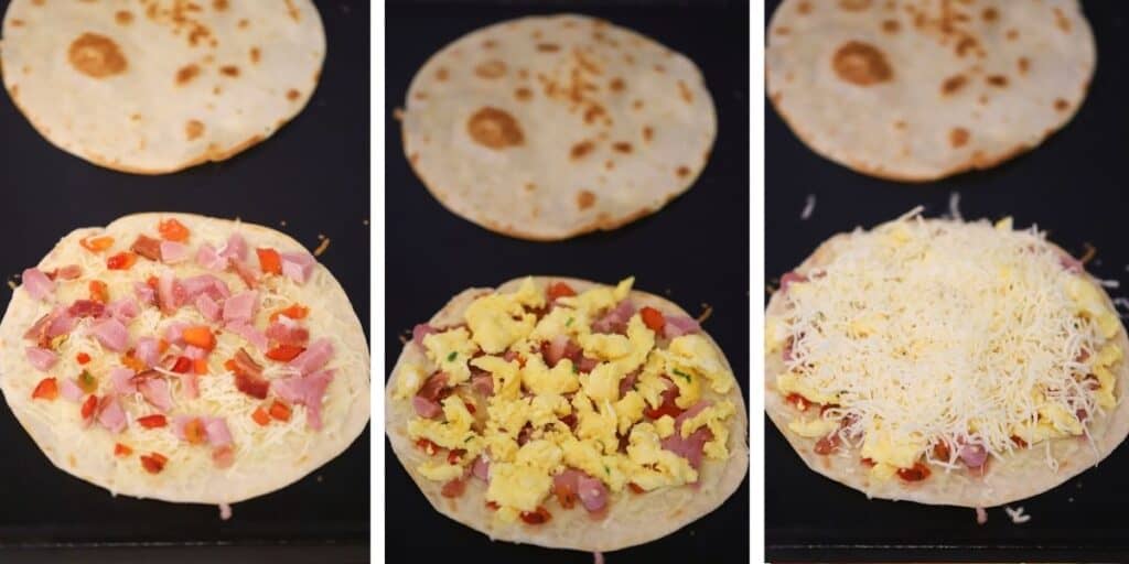 Breakfast quesadillas cooking on a skillet with shredded cheese, scrambled eggs, bacon, and ham.