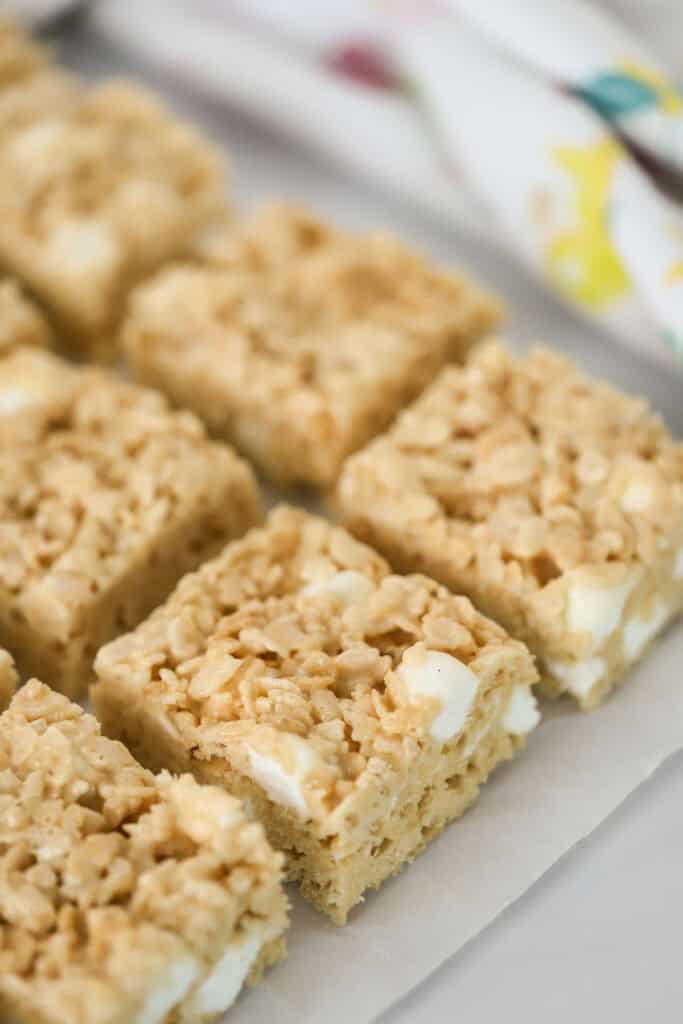Rows of caramel rice krispie treats lined up on a serving plate.