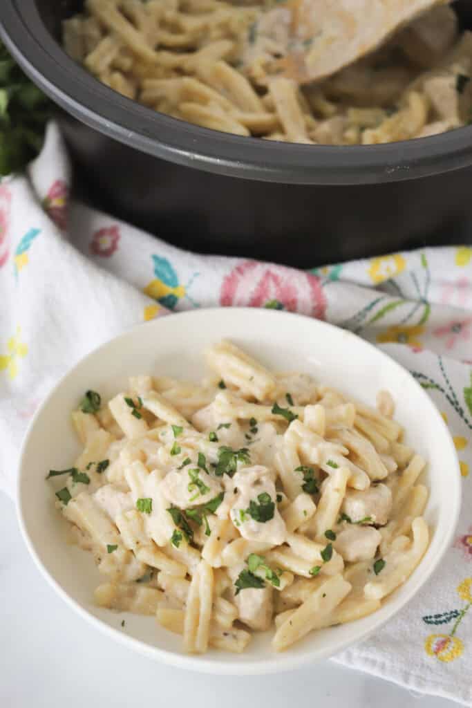 A serving bowl full of creamy lemon thyme chicken pasta, a light and easy lemon chicken recipe for spring and summer.