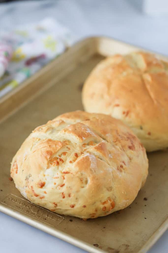 A baking sheet with two freshly baked loaves of rosemary garlic bread.