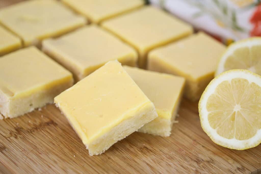 Lemon Blondie squares on a wooden cutting board.