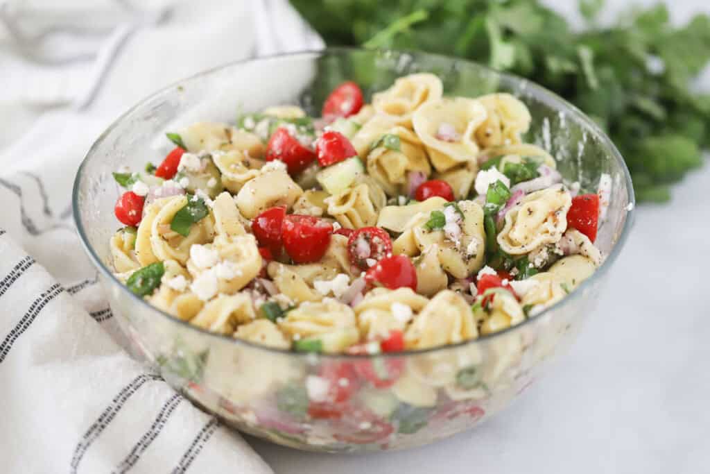 A bowl of greek tortellini pasta salad with homemade greek vinaigrette.