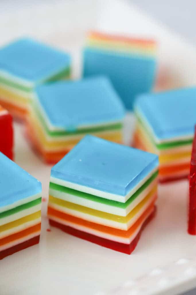 Squares of layered jello in rainbow colors separated by thin white layers.