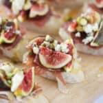 how to make Fig and Prosciutto Crostini recipe, Fig and Prosciutto Crostini on a white platter.