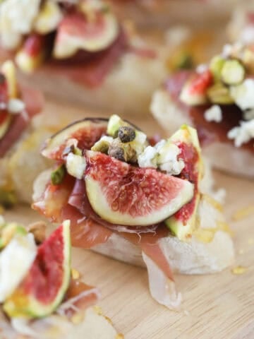 how to make Fig and Prosciutto Crostini recipe, Fig and Prosciutto Crostini on a white platter.