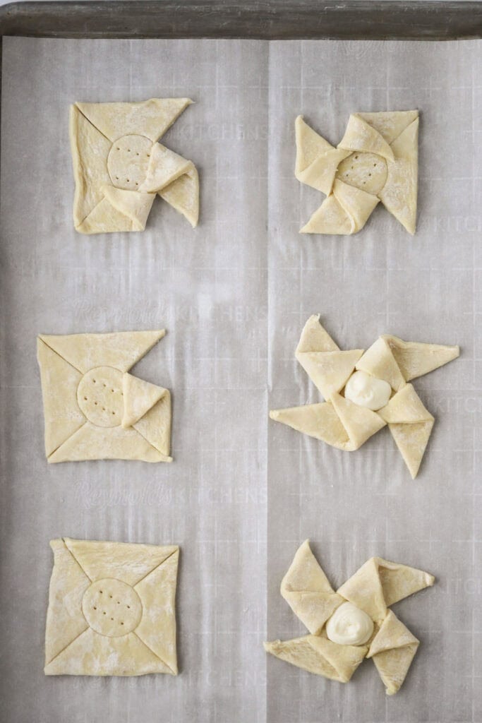 Showing how to fill and fold up these cream cheese Danish pastries.