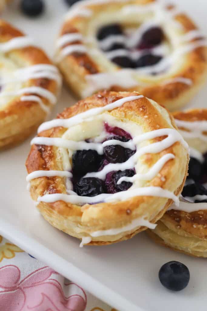 A plate full of blueberry danish topped with homemade glaze.