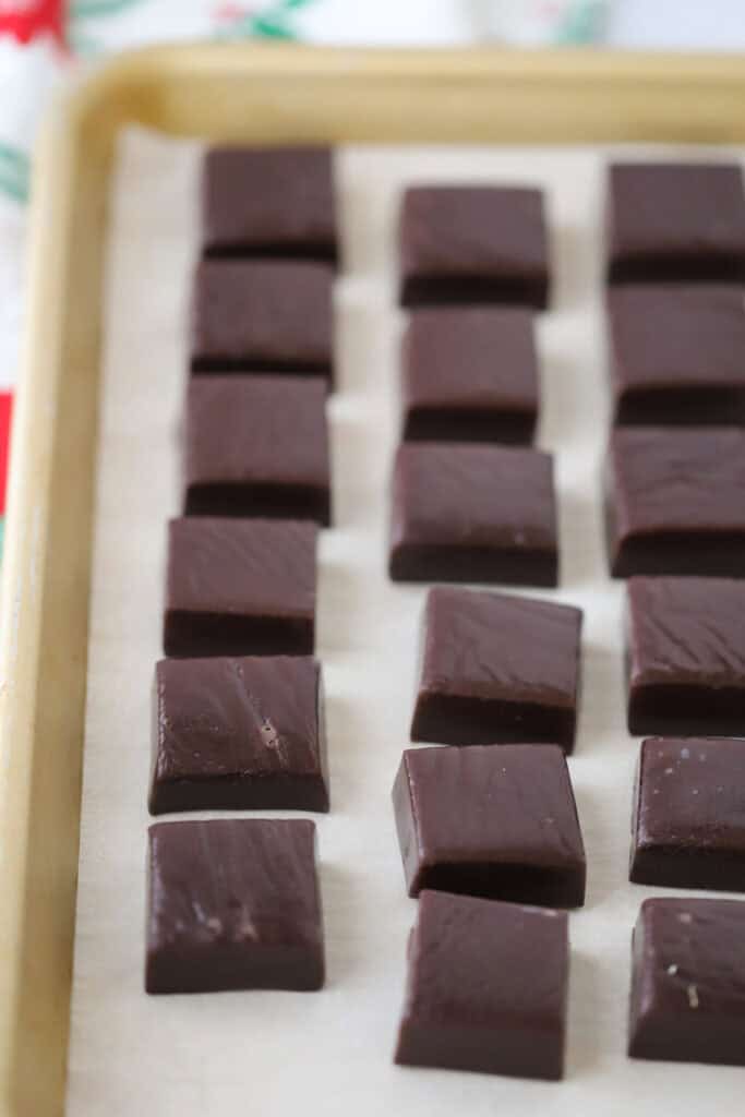 A tray full of cut black licorice caramels.