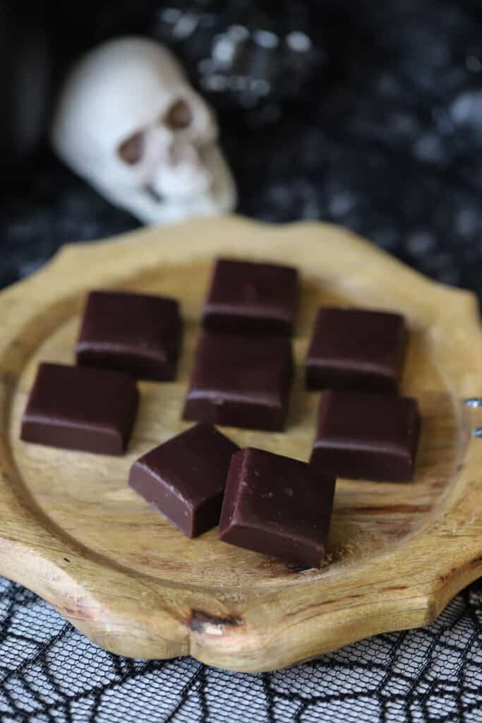 Homemade caramel candies on a wooden serving tray.