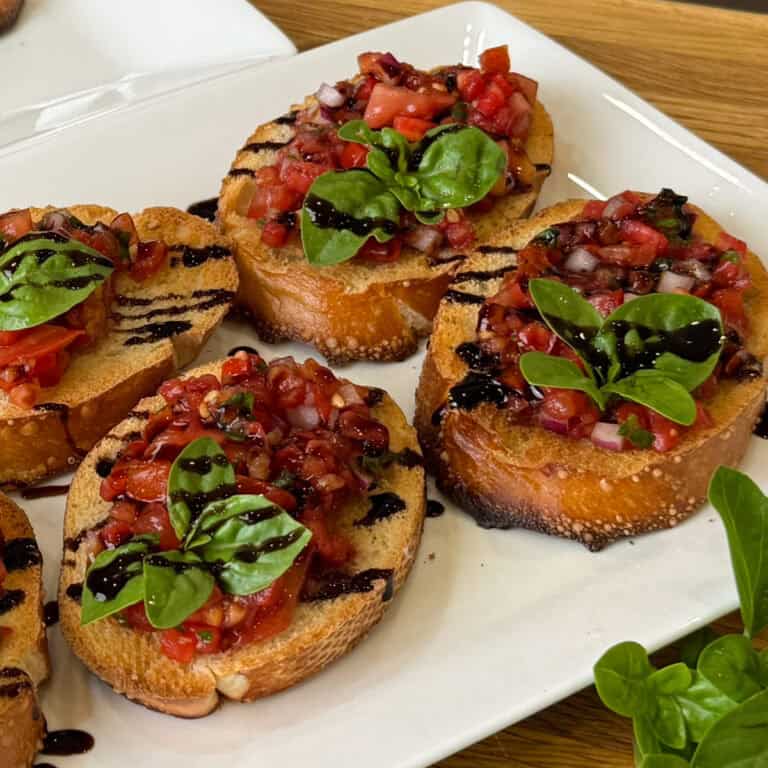 easy bruschetta with fresh tomatoes and basil and drizzle of balsamic glaze.