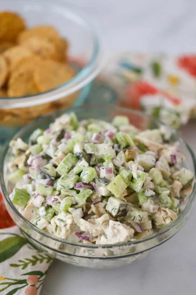 A glass bowl full of dill pickle chicken salad.