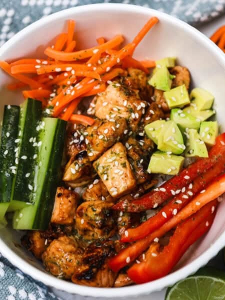 honey citrus salmon bowls recipe, salmon with sliced fresh veggies on rice.