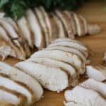 slow cooker simple chicken breast recipe on a cutting board showing juicy chicken.