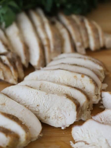 slow cooker simple chicken breast recipe on a cutting board showing juicy chicken.