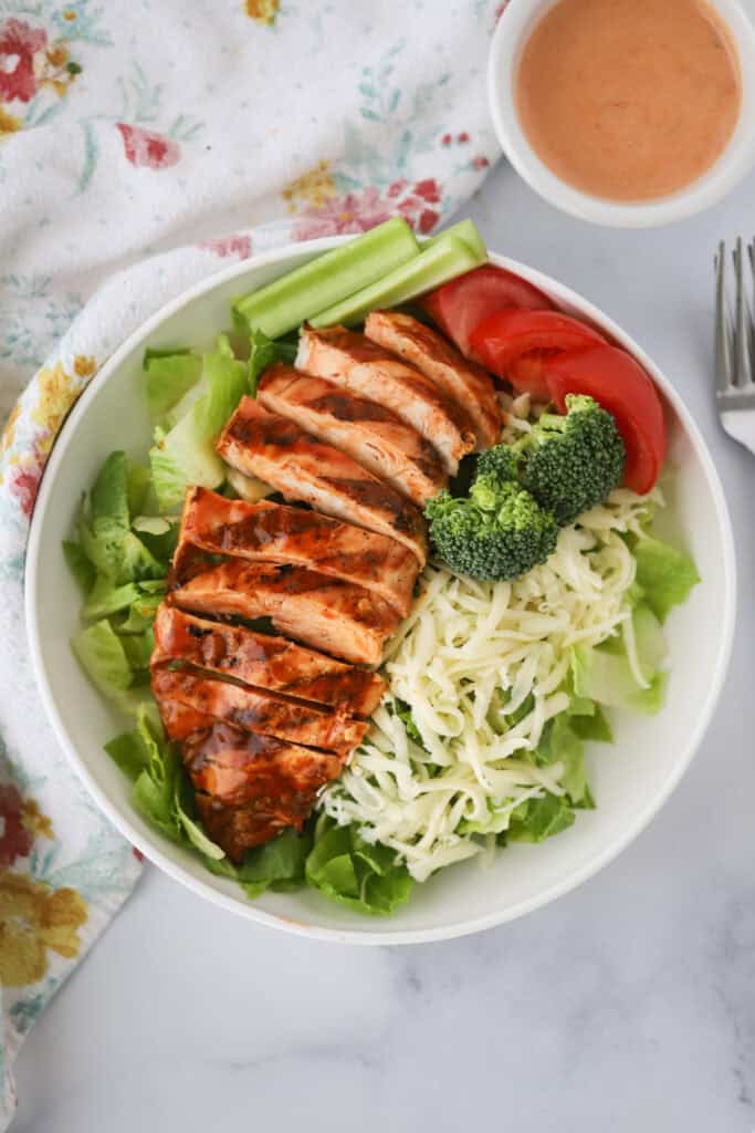 Grilled buffalo chicken salad recipe on a white dinner plate.