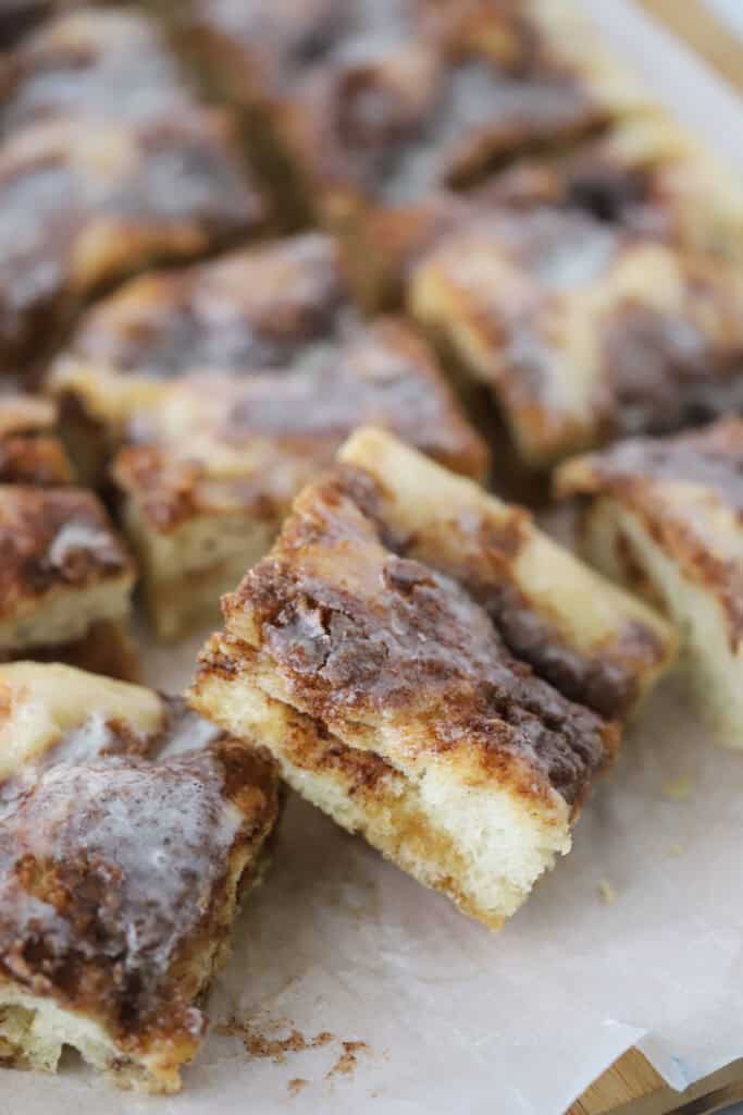 Squares of cinnamon roll focaccia on a cutting board.