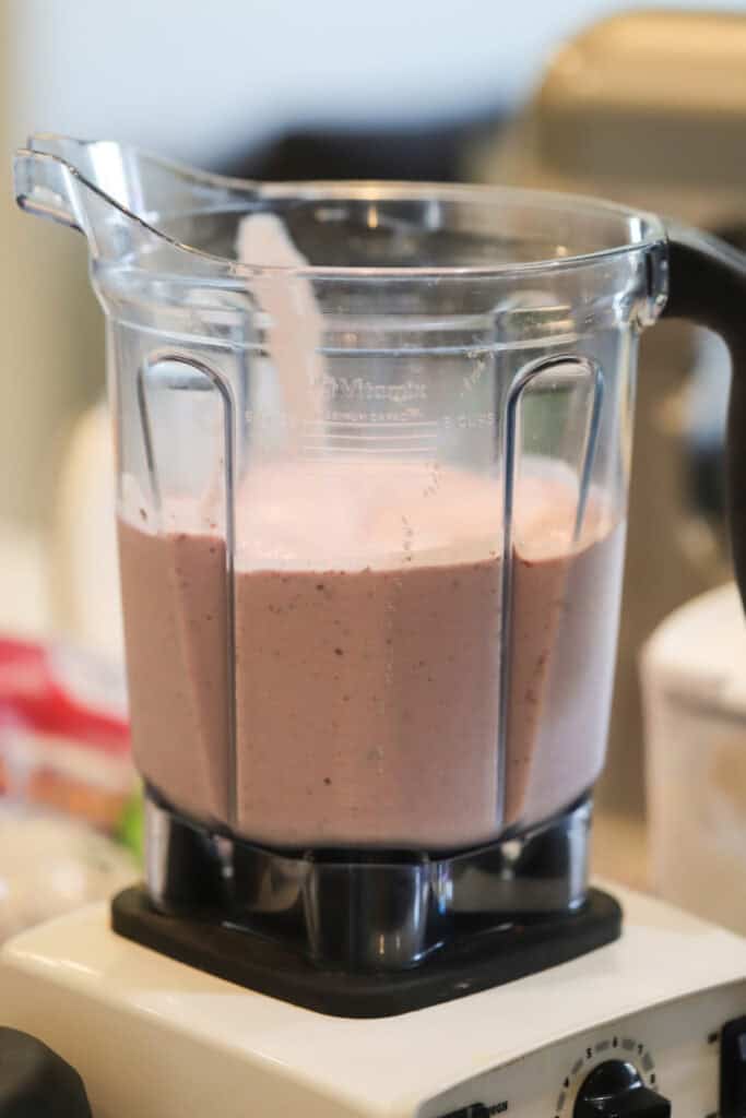 A blender full of strawberry smoothie.