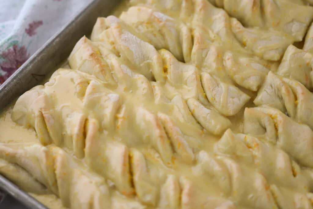 Orange roll breadsticks in a baking pan.