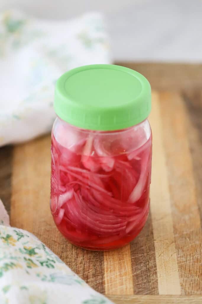 A jar full of quick pickled red onions.