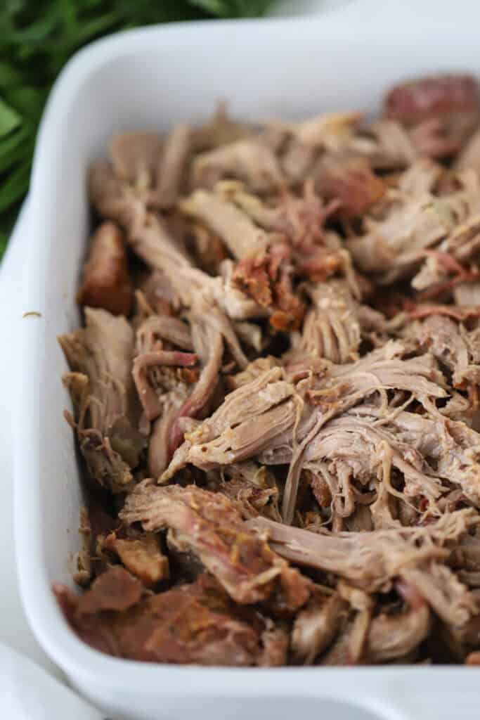 Smoked pulled pork in a white baking dish.