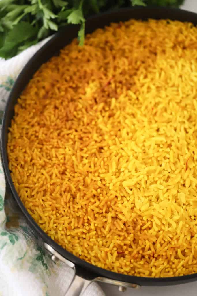 A saute pan full of yellow rice (or arroz amarillo).