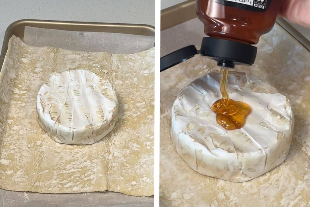 A sheet tray with a sheet of puff pastry, a round of brie cheese in the center, and honey being added to the top.