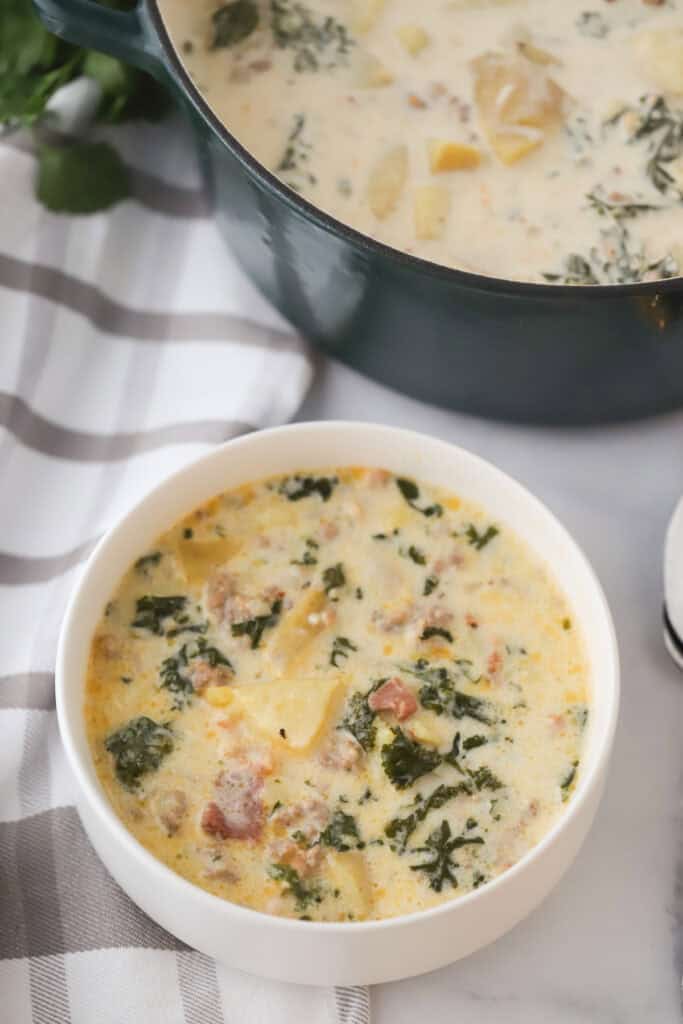 A big bowl full of Zuppa Toscana filled with sausage, potatoes, and kale.