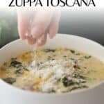 easy recipe for Zuppa Toscana Soup in a white bowl sprinkling parmesan on top.
