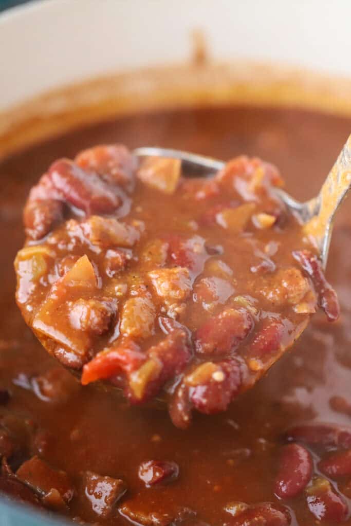 Brisket Chili in a Dutch oven with a ladle.