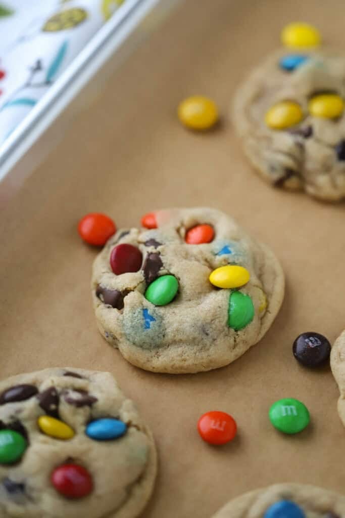 A baking sheet with freshly baked peanut butter and M&M cookies.