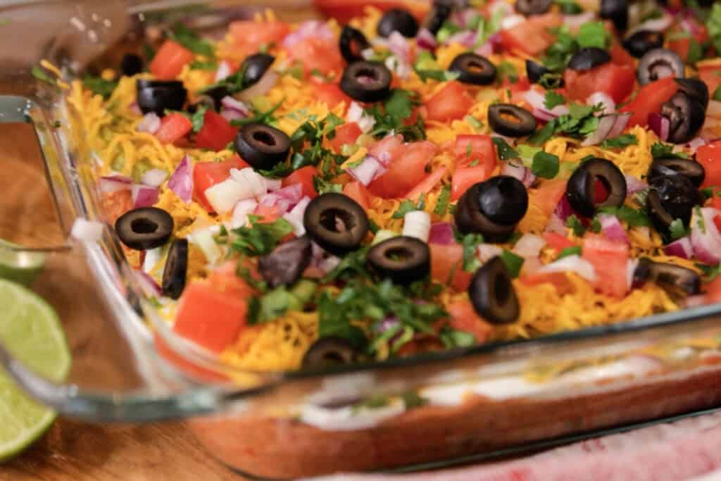 tex mex 7 layer bean dip recipe in a glass baking dish