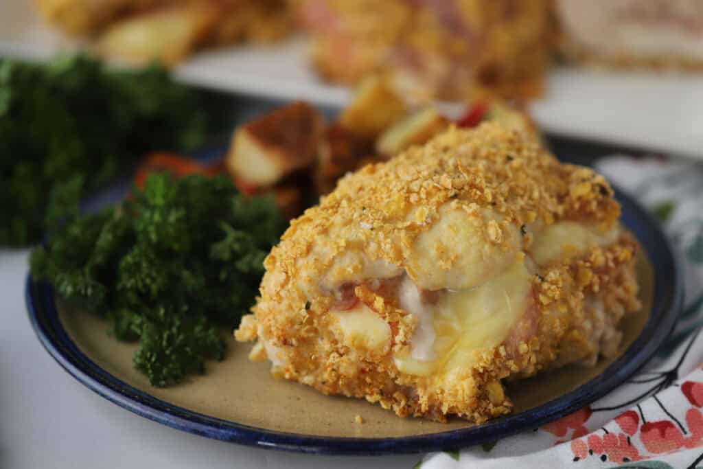 A dinner plate with a serving of homemade chicken cordon bleu and a side salad.