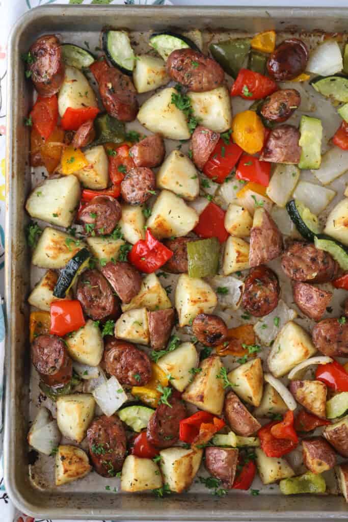 Sheet pan sausage and veggies  roasted and spread out.