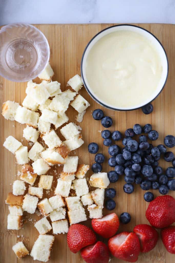 Ingredients for building these berry parfait with pound cake on a cutting board.