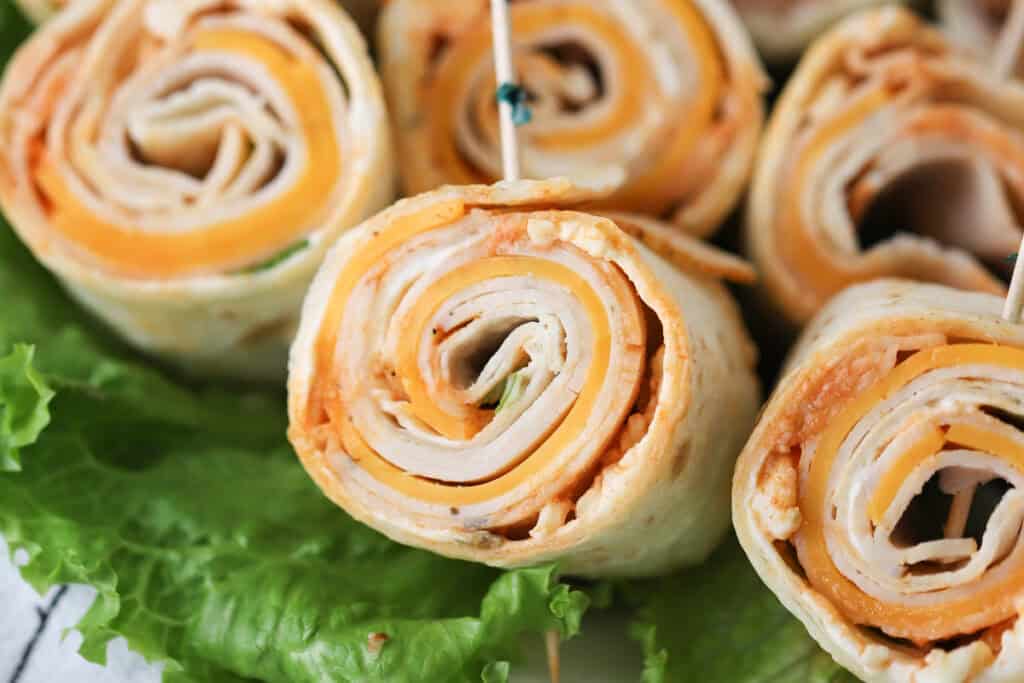 Buffalo chicken roll ups on a platter.
