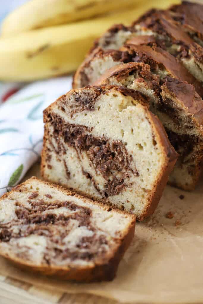 A sliced loaf of Nutella Swirl Banana Bread on a counter.